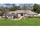 Charming single-story home boasts a well-manicured lawn, mature trees, and a welcoming red double-door entrance at 6279 Se 8Th Lane, Ocala, FL 34472