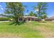 Beautiful single-story home featuring a lush front yard, large windows, and an American flag at 6279 Se 8Th Lane, Ocala, FL 34472