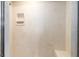 Stylish shower featuring elegant marble-look wall tiles, a convenient shelf, and a built-in corner seat at 6279 Se 8Th Lane, Ocala, FL 34472