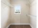 Walk-in closet featuring wire shelving, a window for natural light, and carpet flooring at 6279 Se 8Th Lane, Ocala, FL 34472