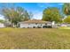 Well-maintained backyard features lush lawn and mature plantings around the home's perimeter at 6450 Sw 83Rd Ln, Ocala, FL 34476