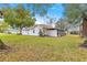 Expansive backyard with lush greenery, mature trees, and a charming white home exterior at 6450 Sw 83Rd Ln, Ocala, FL 34476