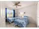 Comfortable bedroom featuring a ceiling fan, natural light, and two beds with blue accents at 6450 Sw 83Rd Ln, Ocala, FL 34476
