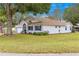Well-manicured home exterior with a lush green lawn, mature trees, and a welcoming facade at 6450 Sw 83Rd Ln, Ocala, FL 34476
