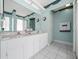 Well-lit bathroom with double sink vanity, white tile floors, and framed mirror at 7178 Sw 113Th Loop, Ocala, FL 34476