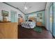 Comfortable bedroom features hardwood floors, neutral paint, updated ceiling fan and sliding glass door at 7178 Sw 113Th Loop, Ocala, FL 34476