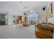 A spacious, well-lit living room with tiled floors, a ceiling fan, and multiple windows at 7178 Sw 113Th Loop, Ocala, FL 34476