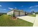 Side view of home featuring attached two car garage and a well-manicured lawn at 7374 Sw 77Th Ave, Ocala, FL 34481