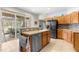Bright kitchen features wood cabinetry, stainless steel appliances, and a view to the outside patio and yard at 8782 Sw 82Nd Court Rd, Ocala, FL 34481