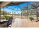 Outdoor screened patio featuring tile flooring, an outdoor dining set, and a backyard view of the golf course at 8782 Sw 82Nd Court Rd, Ocala, FL 34481