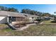 View of the backyard with a retaining wall and fresh mulch leading to the back of the home with screened in porch at 9504 Sw 97Th Ln # B, Ocala, FL 34481