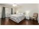 Calm bedroom features wood floors, bedside tables, and a window with sheer curtains at 9504 Sw 97Th Ln # B, Ocala, FL 34481