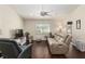 Cozy living room features wood floors, ceiling fan, a comfortable sofa and a window with plantation shutters at 9504 Sw 97Th Ln # B, Ocala, FL 34481