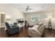 Comfortable living room with wood floors, ceiling fan, a sofa, arm chair and window with plantation shutters at 9504 Sw 97Th Ln # B, Ocala, FL 34481