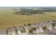 An aerial shot showcases a tranquil neighborhood next to expansive green fields with grazing livestock at 9863 Sw 63Rd Loop, Ocala, FL 34481