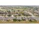 An aerial view of a quiet residential neighborhood with well-kept lawns and houses, and a scenic golf course in the background at 9863 Sw 63Rd Loop, Ocala, FL 34481