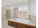 Bathroom showcasing soaking tub, separate shower stall and shuttered windows at 9863 Sw 63Rd Loop, Ocala, FL 34481