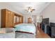 Primary bedroom with ceiling fan, built-in storage, TV, and wood flooring at 9863 Sw 63Rd Loop, Ocala, FL 34481