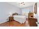 Cozy bedroom with hardwood floors, a wicker bed frame, and natural light, offering a warm, inviting feel at 9863 Sw 63Rd Loop, Ocala, FL 34481