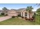 Charming single-story home with a well-manicured lawn, mature landscaping, and a brick-paved driveway at 9863 Sw 63Rd Loop, Ocala, FL 34481