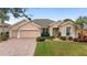 Inviting single-story home featuring a brick driveway, a two-car garage, and attractive landscaping at 9863 Sw 63Rd Loop, Ocala, FL 34481