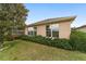 Exterior view of a home's back side with tidy landscaping, windows, and a screened-in porch visible at 9863 Sw 63Rd Loop, Ocala, FL 34481