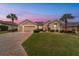 Inviting single-Gathering home with a well-manicured lawn, paver driveway and two-car garage, complemented by palm trees at 9863 Sw 63Rd Loop, Ocala, FL 34481