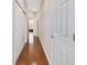 Hallway view with hardwood floors, neutral walls, and white doors enhancing the home's clean aesthetic at 9863 Sw 63Rd Loop, Ocala, FL 34481