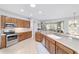 Open kitchen boasts stainless steel appliances, tile floors, light countertops, and view to the living room at 9863 Sw 63Rd Loop, Ocala, FL 34481