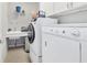 Functional laundry room with washer, dryer, utility sink, and storage, streamlining household tasks at 9863 Sw 63Rd Loop, Ocala, FL 34481