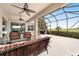 Relaxing screened patio with ceiling fans and an outdoor cooking area overlooking a large fenced back yard at 9863 Sw 63Rd Loop, Ocala, FL 34481