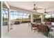 Relaxing screened patio with multiple ceiling fans and an outdoor cooking area overlooking a large fenced back yard at 9863 Sw 63Rd Loop, Ocala, FL 34481
