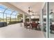Relaxing screened patio with multiple ceiling fans and an outdoor cooking area overlooking a large fenced back yard at 9863 Sw 63Rd Loop, Ocala, FL 34481