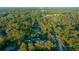 A high aerial perspective of this property with a swimming pool amid dense trees at 4040 E Fort King St, Ocala, FL 34470