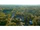 An aerial shot highlights this home with a pool nestled within a lush, treed landscape at 4040 E Fort King St, Ocala, FL 34470