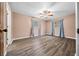 Spacious bedroom with wood-look floors, ceiling fan, and blue curtains at 4040 E Fort King St, Ocala, FL 34470