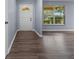 Inviting foyer featuring wood-look floors, a white front door, and natural light from the window at 4040 E Fort King St, Ocala, FL 34470