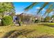 Landscaped backyard featuring a screened-in lanai and lush green lawn at 10055 Sw 90Th Loop, Ocala, FL 34481