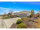 Inviting single-story home featuring a spacious driveway, manicured shrubs, and a two-car garage at 10055 Sw 90Th Loop, Ocala, FL 34481