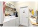 Bright laundry room features a washer, dryer, and shelf space at 10055 Sw 90Th Loop, Ocala, FL 34481