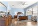 Spacious primary bedroom with hardwood floors, ceiling fan, and a large window at 10055 Sw 90Th Loop, Ocala, FL 34481