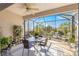 Relaxing screened patio boasts ceiling fan, dining set, ample seating, and lush backyard views at 10055 Sw 90Th Loop, Ocala, FL 34481