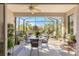Relaxing screened patio boasts ceiling fan, dining set, ample seating, and beautiful backyard views at 10055 Sw 90Th Loop, Ocala, FL 34481