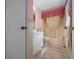 Charming bathroom with pink accents, tub with shower curtain, and vintage-inspired decor at 1019 Avalon Ave, Lady Lake, FL 32159