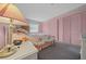 Serene bedroom with pink accents, textured carpeting, and abundant natural light through the window at 1019 Avalon Ave, Lady Lake, FL 32159