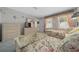 Comfortable bedroom with coordinated floral bedding and wallpaper plus dresser with mounted tv at 1019 Avalon Ave, Lady Lake, FL 32159