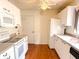 View of kitchen features white appliances and cabinetry with hard wood floors at 1019 Avalon Ave, Lady Lake, FL 32159