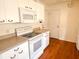 Cozy kitchen features white appliances, wood floor, and ample countertop space at 1019 Avalon Ave, Lady Lake, FL 32159