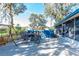 Outdoor patio featuring a dining set, swing, blue wooden fence, and lush trees for a cozy entertainment space at 10376 Se 43Rd Ct, Belleview, FL 34420