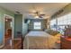 Cozy bedroom featuring hardwood floors, ceiling fan, and a comfortable bed with decorative iron frame at 10376 Se 43Rd Ct, Belleview, FL 34420